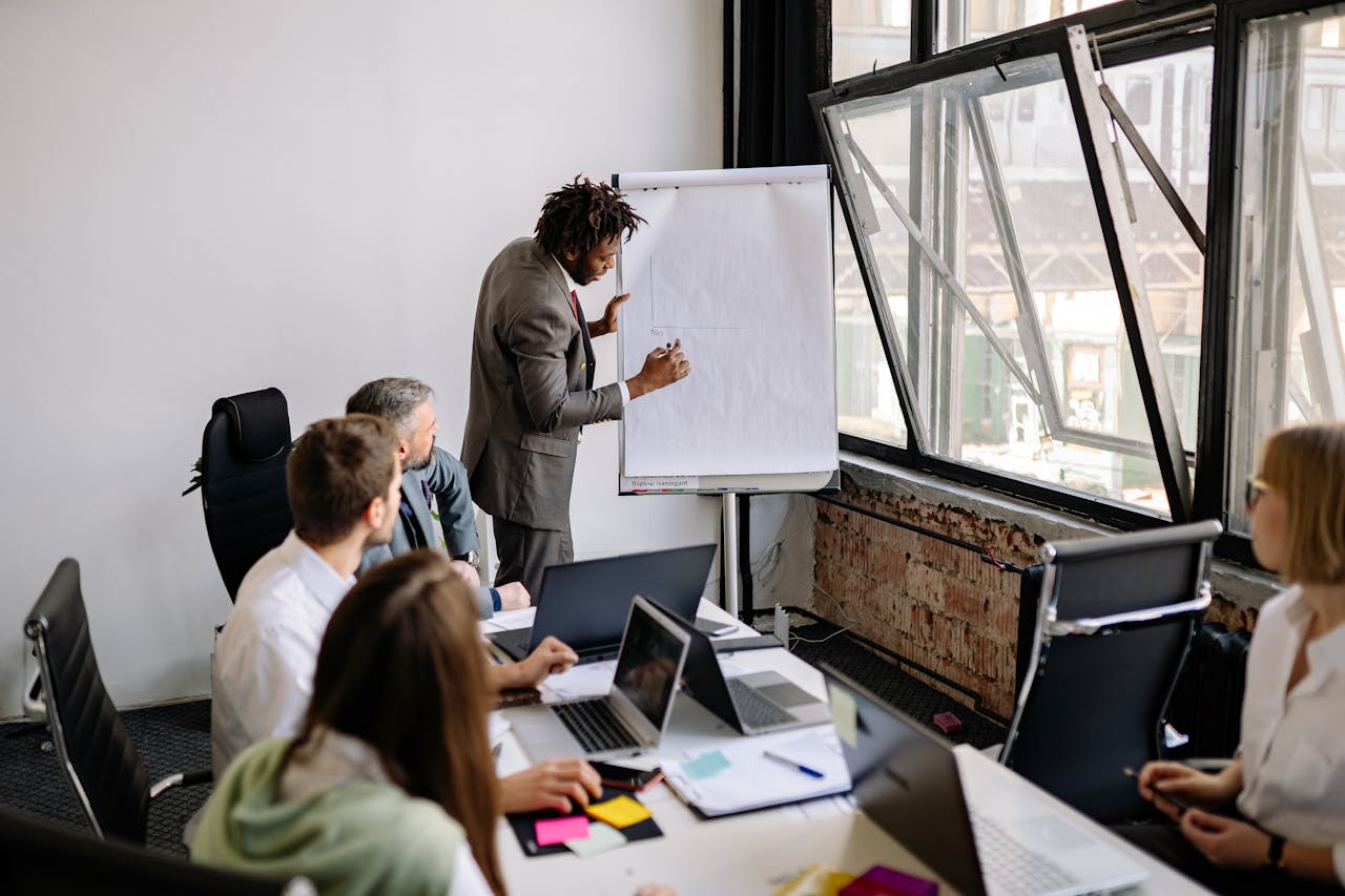 Diverse team engaged in a business meeting with a presentation in a modern office setting.